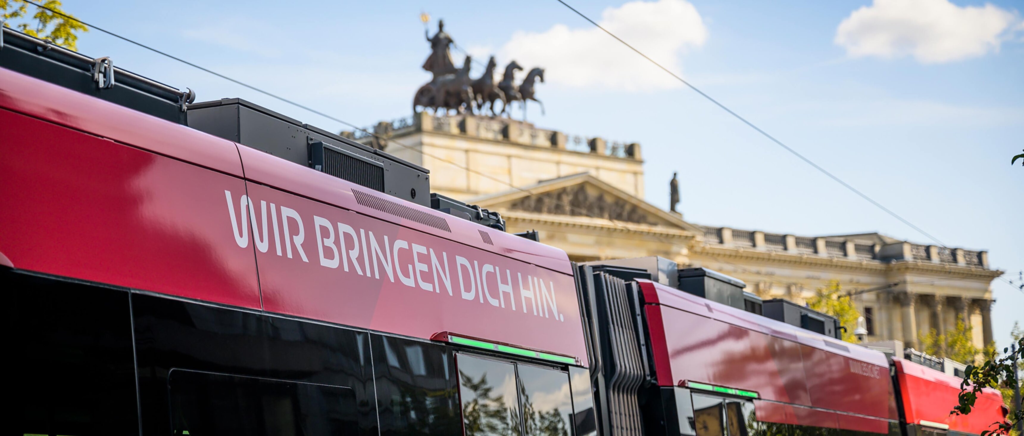 Das Dach einer Straßenbahn mit dem BSVG-Slogan "Wir bringen dich hin". Im Hintergrund ist das Braunschweiger Schloss zu sehen.